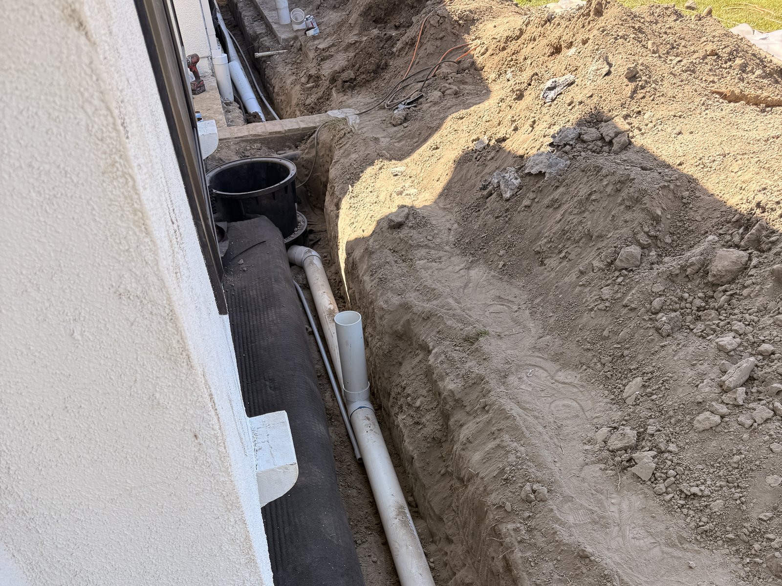 Drainage trench with PVC pipe running along a home's foundation