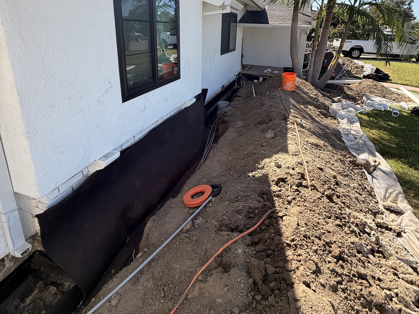 Waterproofing membrane and drain trench along a side wall