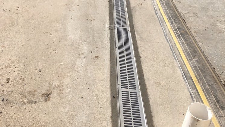 Linear channel drain set into a concrete driveway